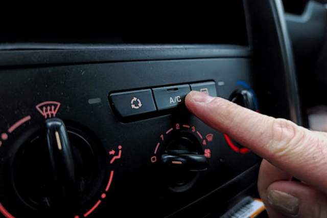 Car air conditioning button being pressed for AC service in Oklahoma City