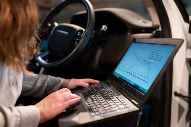 Technician running electrical diagnostics with laptop